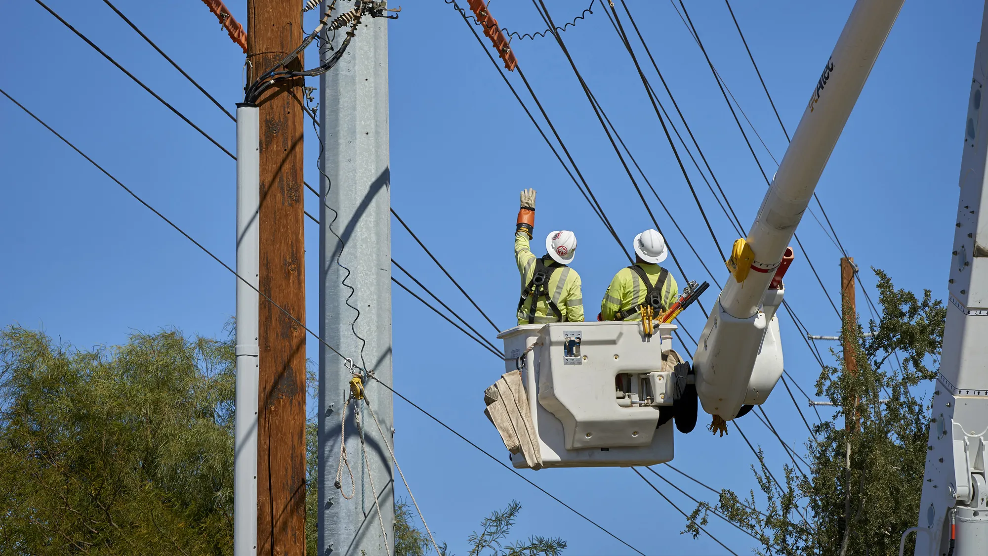 electrical crew in lift working on powerlines