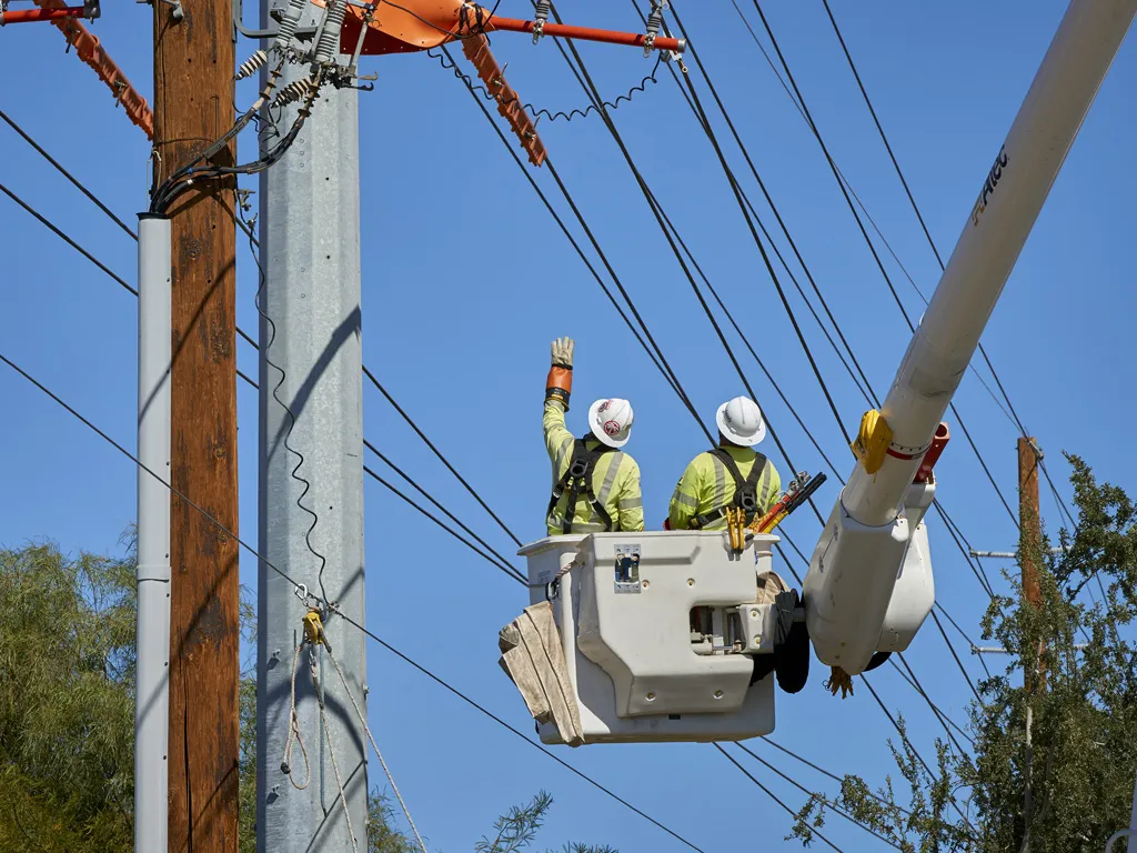 electrical crew in lift working on powerlines
